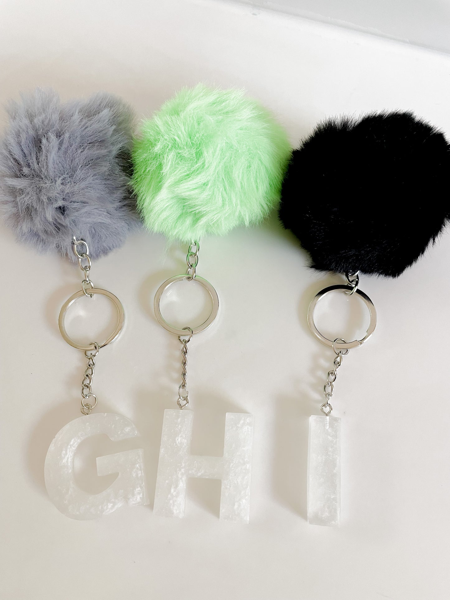 White initial silver keychain w/Pom