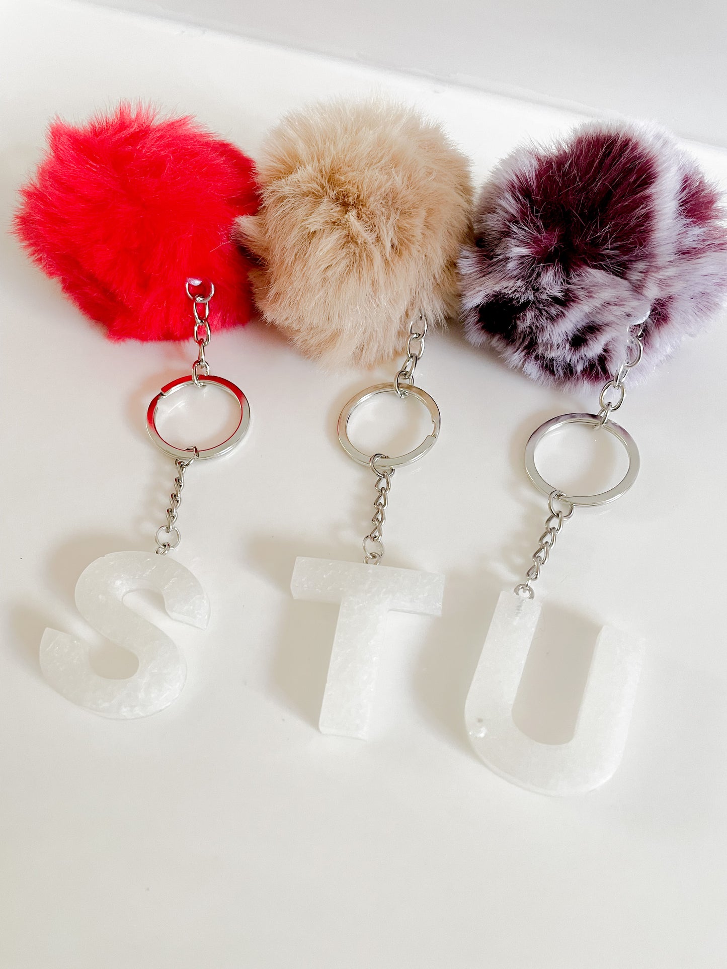White initial silver keychain w/Pom