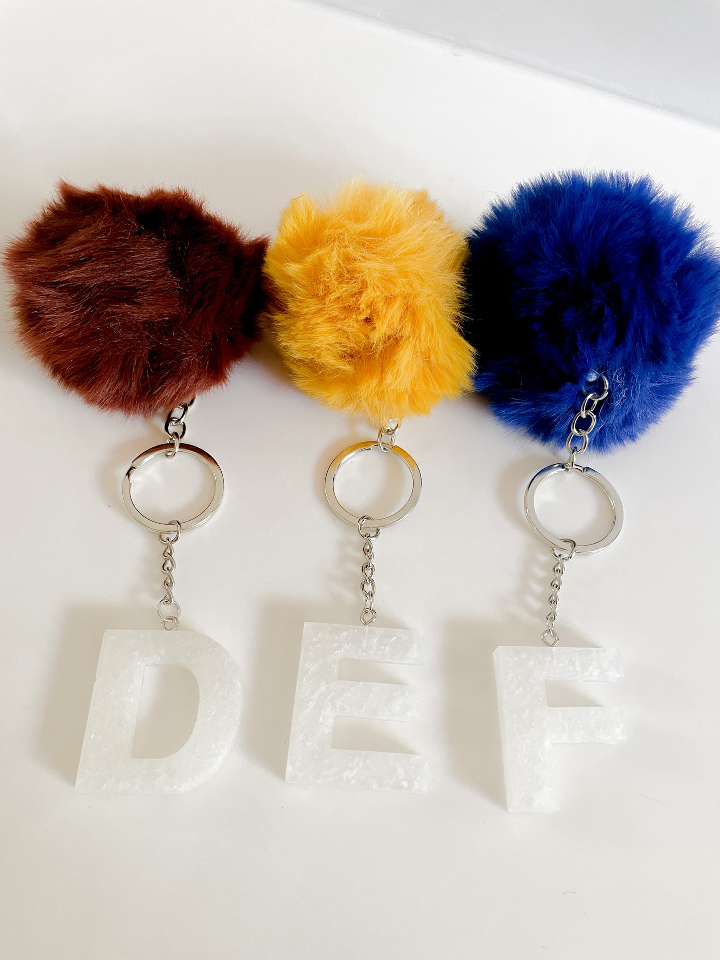 White initial silver keychain w/Pom